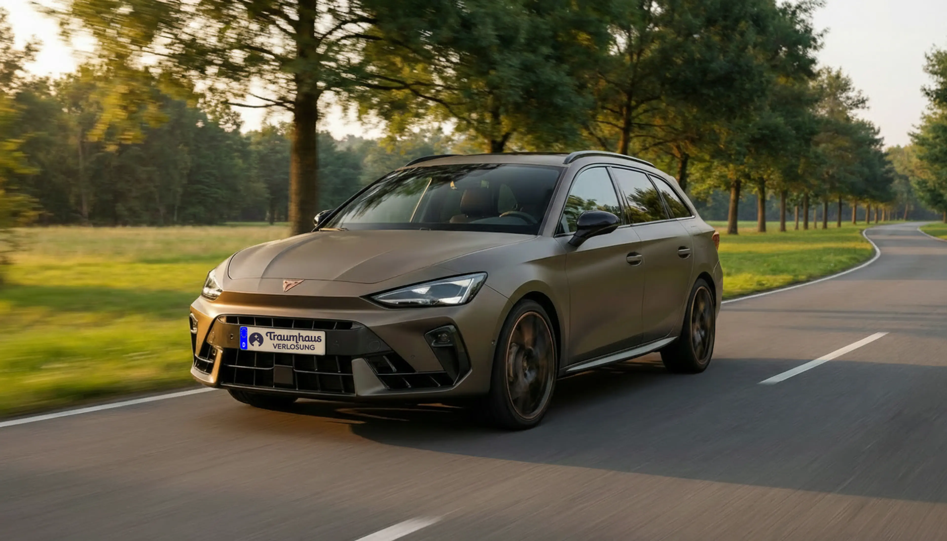 Der Cupra Leon Sportourer von Vorne in olive-grün bei einer Fahr auf einer Landstraße entlang von grünen Wiesen und Wäldern