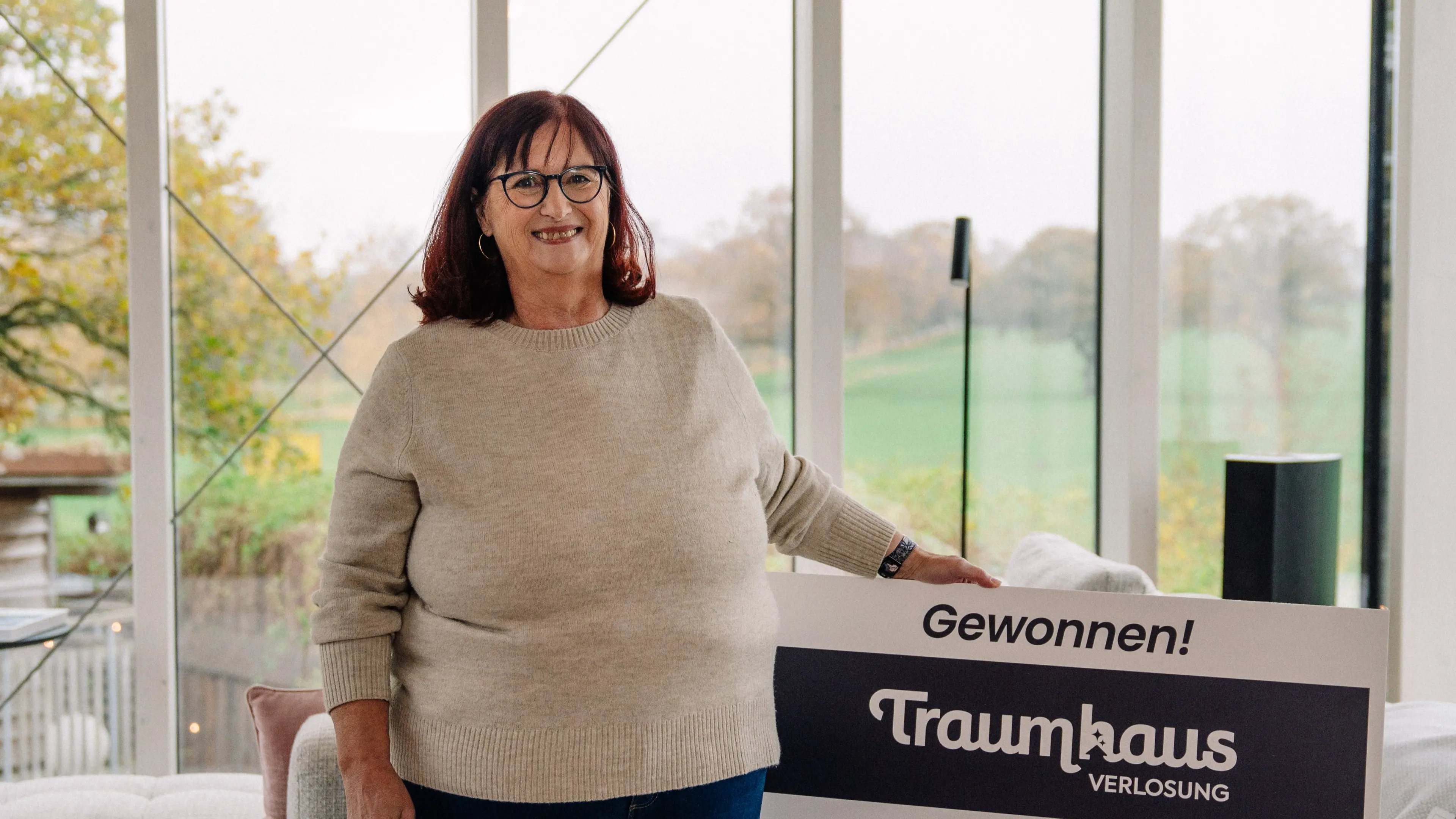 Sabine steht glücklich in ihrem neuen Ostsee-Traumhaus