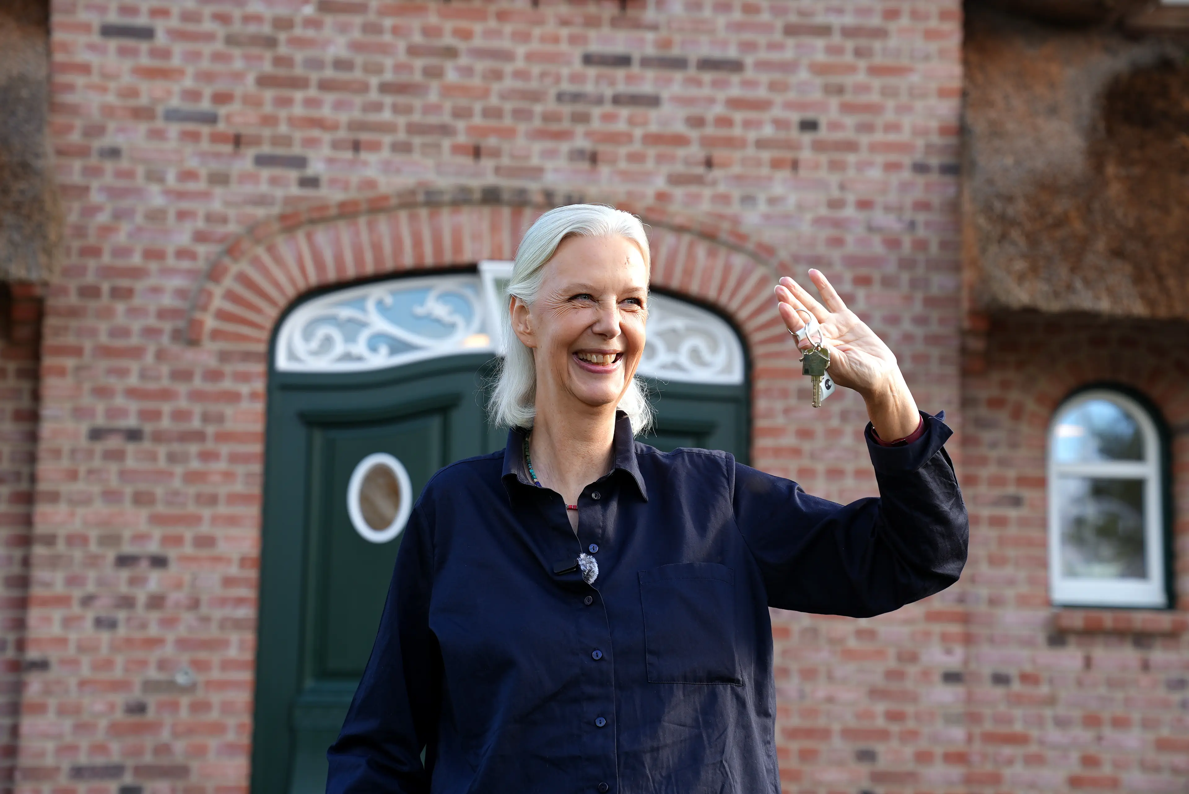 Gewinnerin Elke vor dem Traumhaus mit Ostseeblick