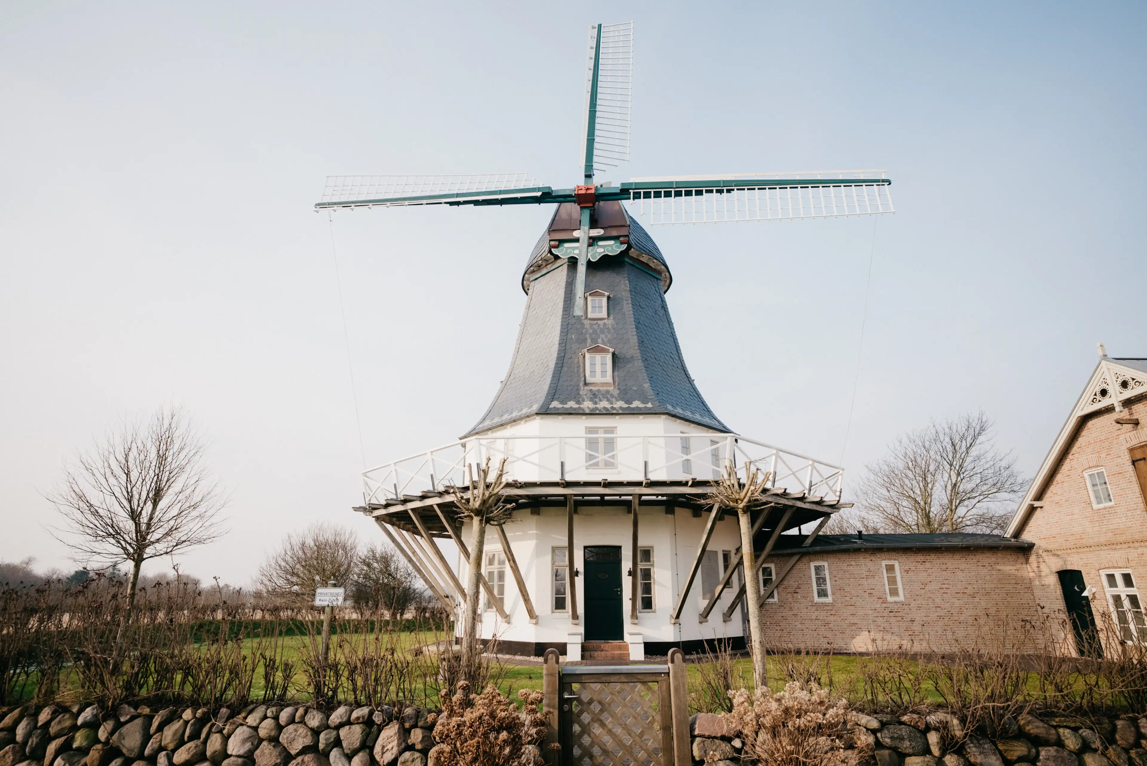 Große historische Windmühle in Weiß- und Grautönen gehalten.