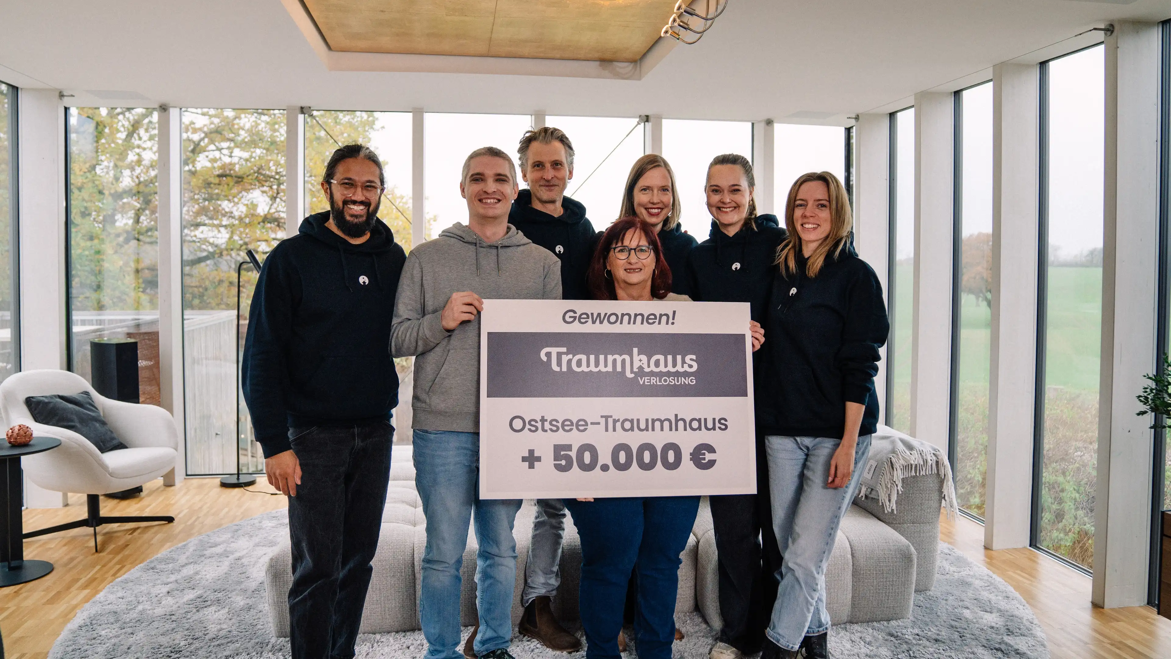 Das Team der Traumhausverlosung und Sabine mit ihrem Sohn bei der Gewinnübergabe