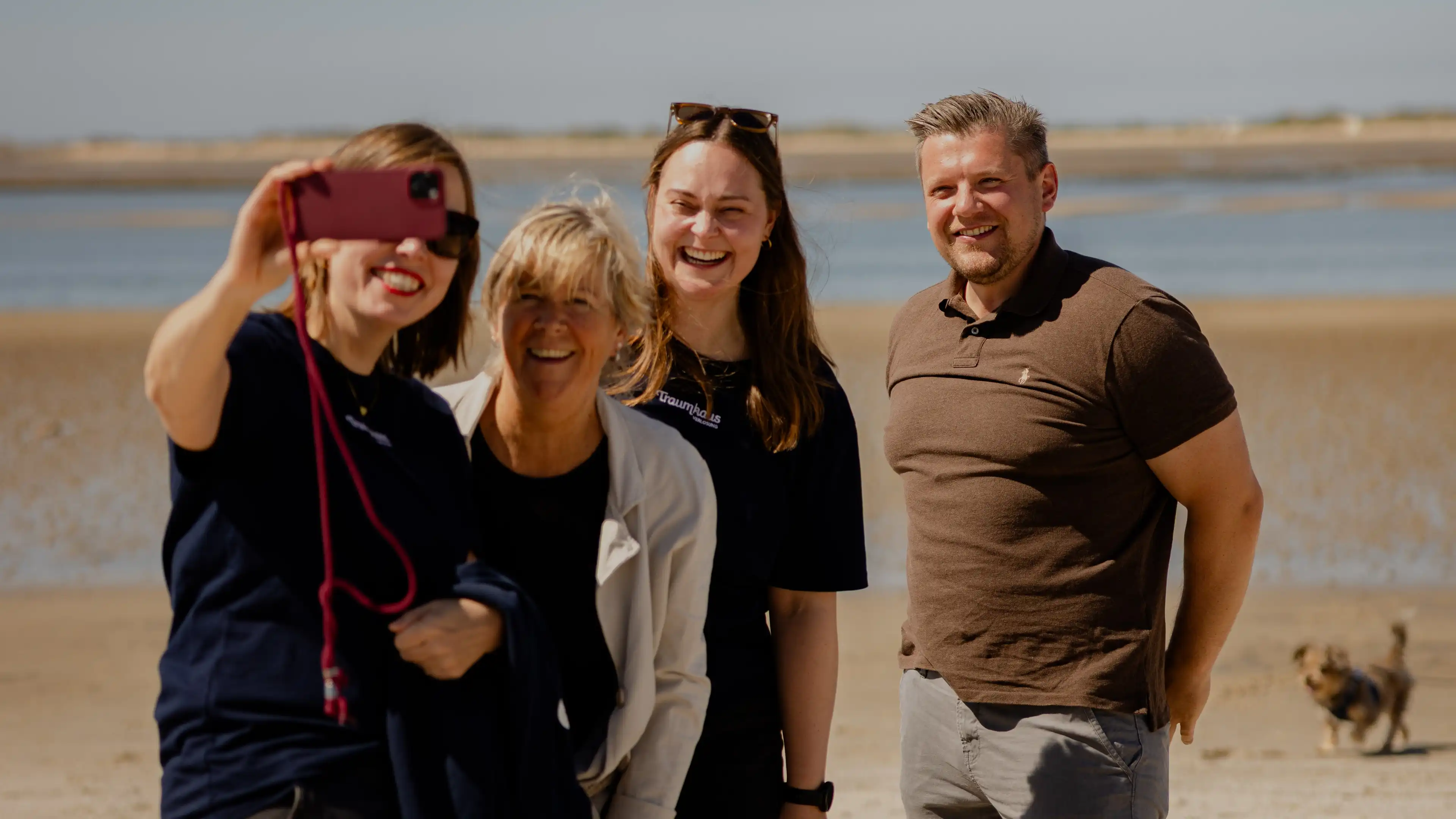 Das Team der Traumhausverlosung und Gewinnerin Birgit mit Sohn machen ein Selfie am Strand von Föhr