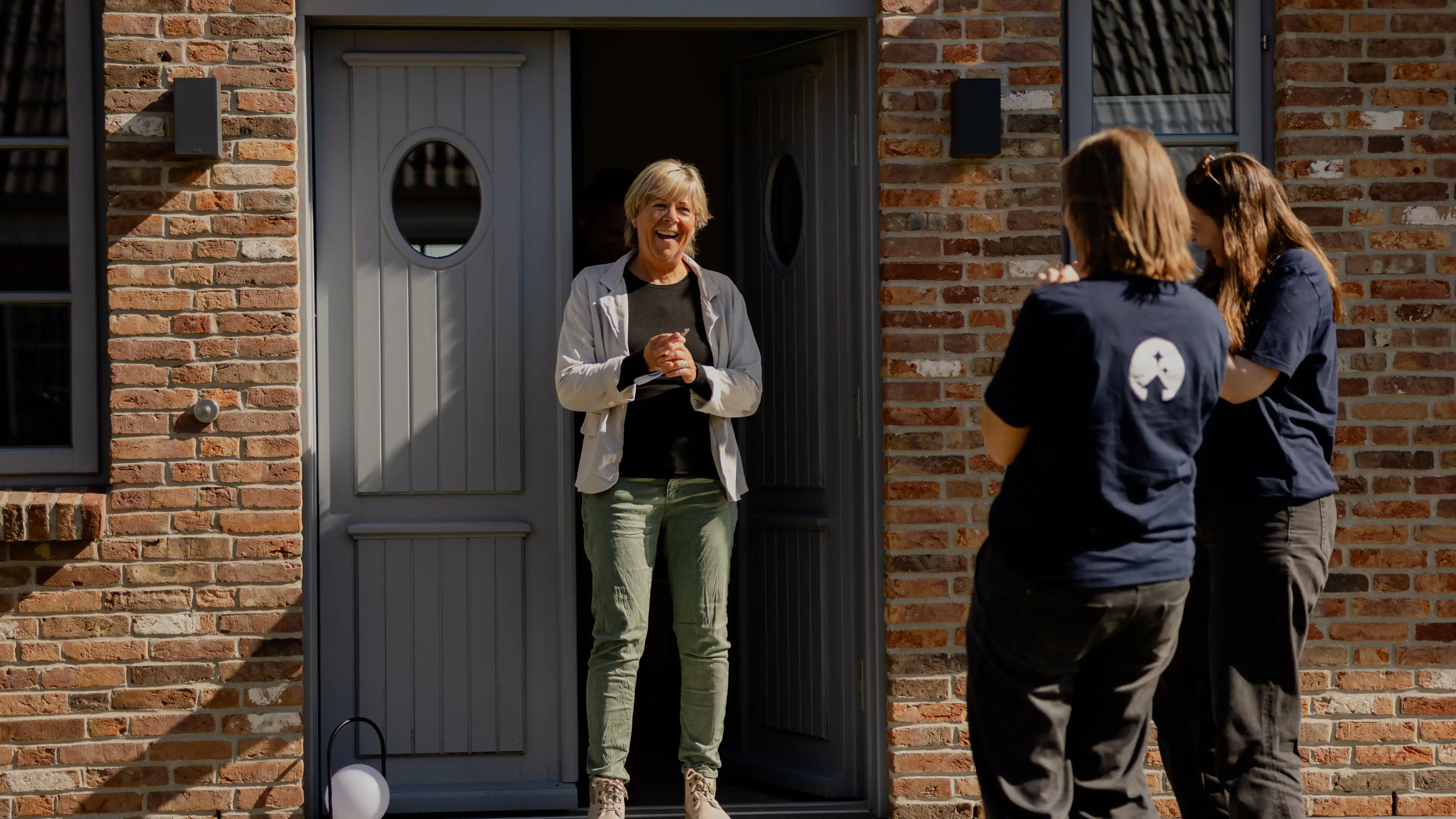 Birgit steht in der Eingangstür des Traumhauses auf Föhr und strahlt übers ganze Gesicht nachdem sie ihr Traumhaus das erste Mal gesehen hat