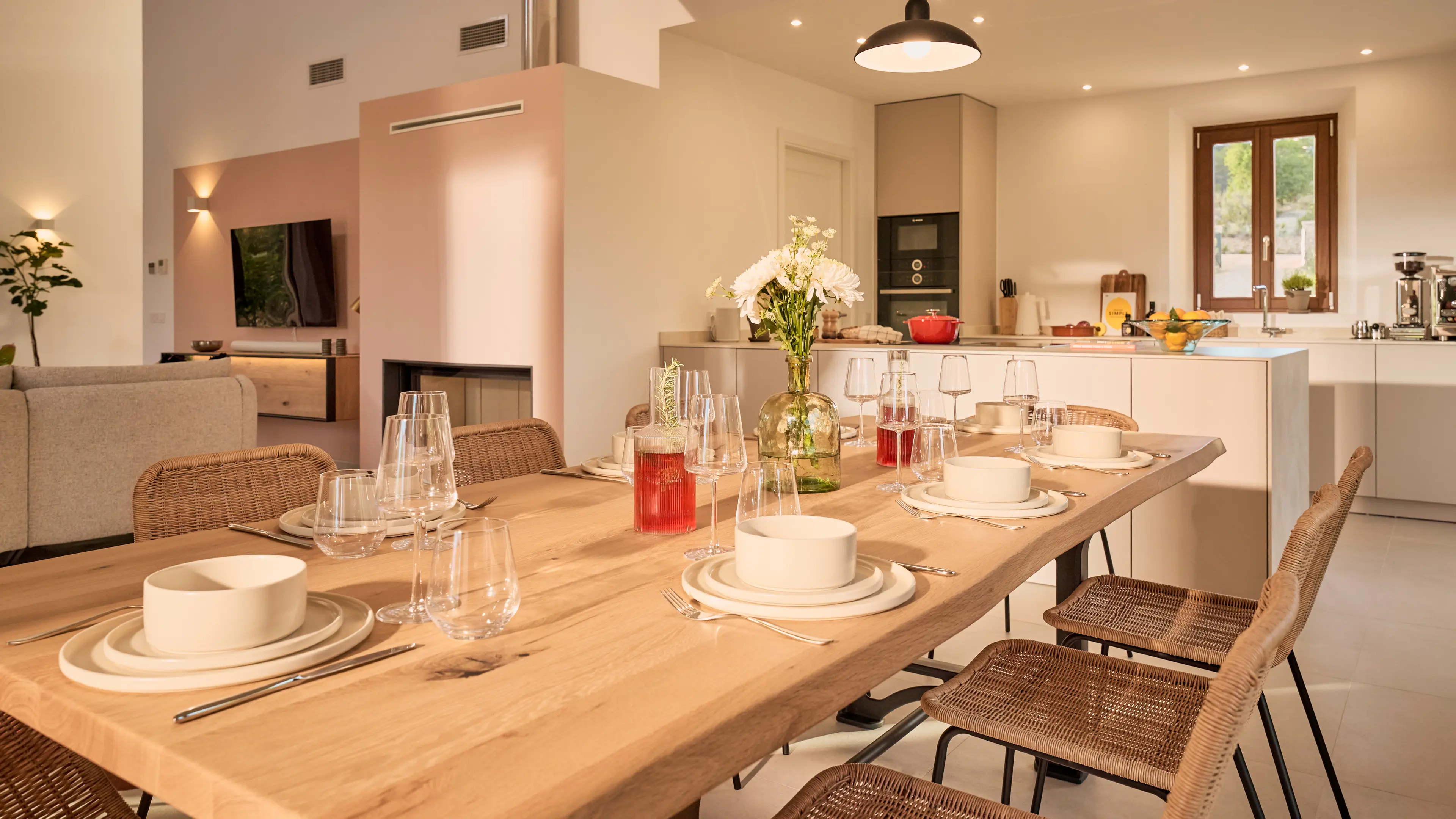 Blick auf den gedeckten Esstisch im Traumhaus auf Mallorca bestehend aus einem großen hellen Holztisch und 8 hellen Rattanstühlen.