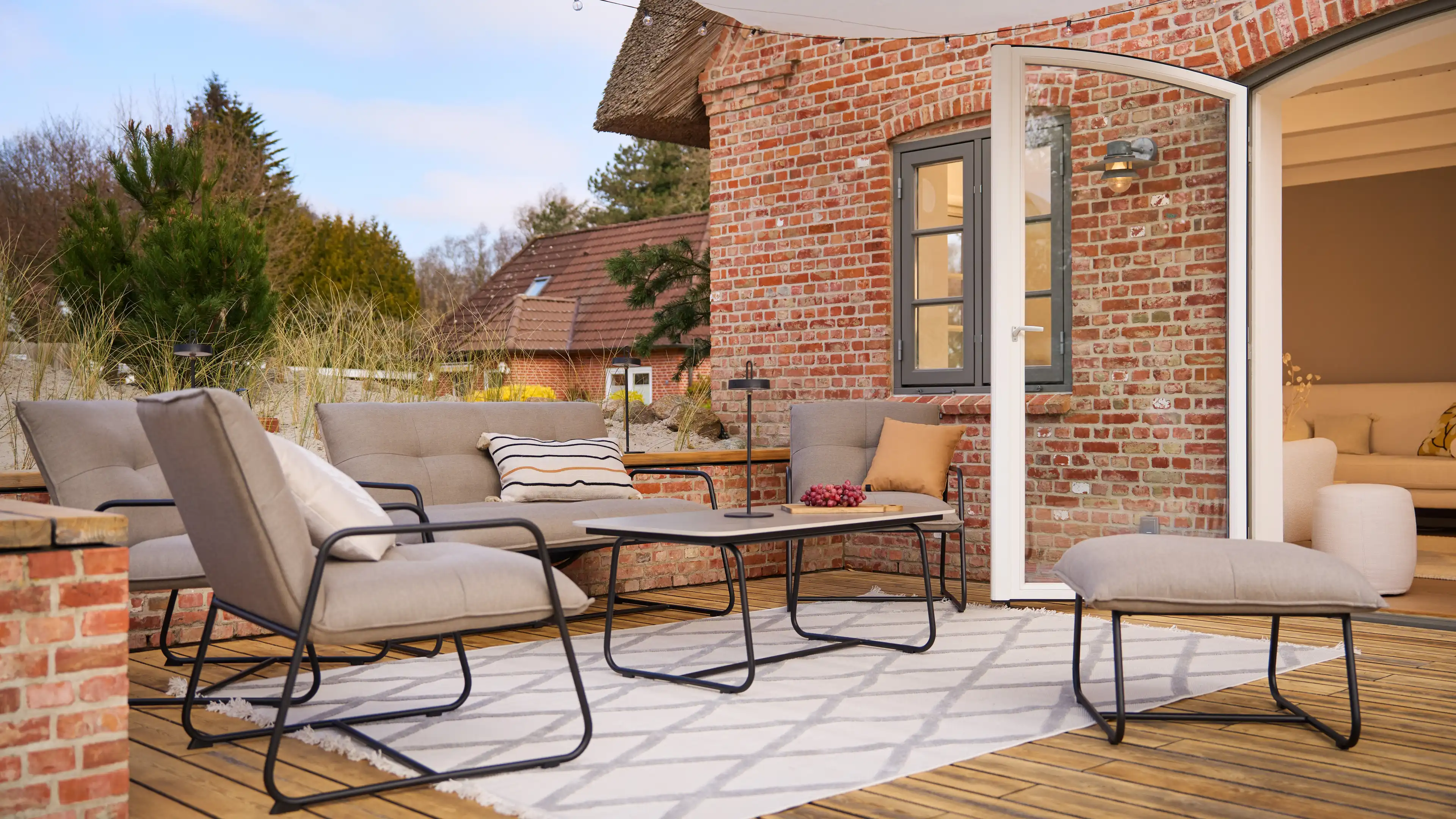 Große Terrasse mit Sonnensegel und gemütlichen Sitzmöbeln der SCHÖNER WOHNEN Kollektion