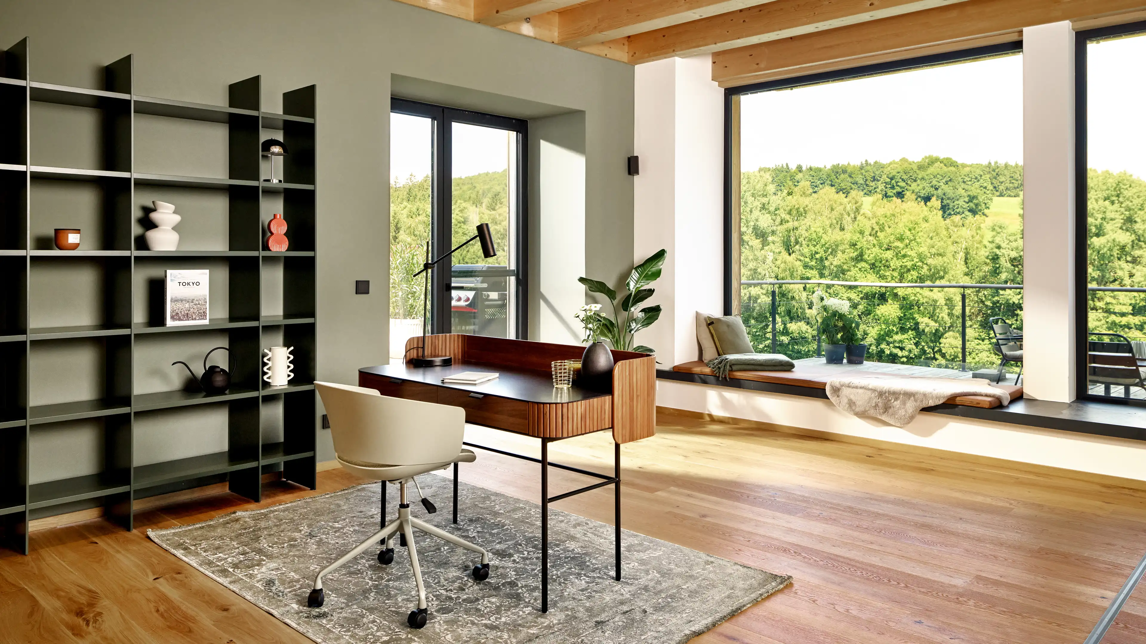 Eine Arbeitsecke umgeben von Panorama-Fenstern mit Blick in den Bayerischen Wald