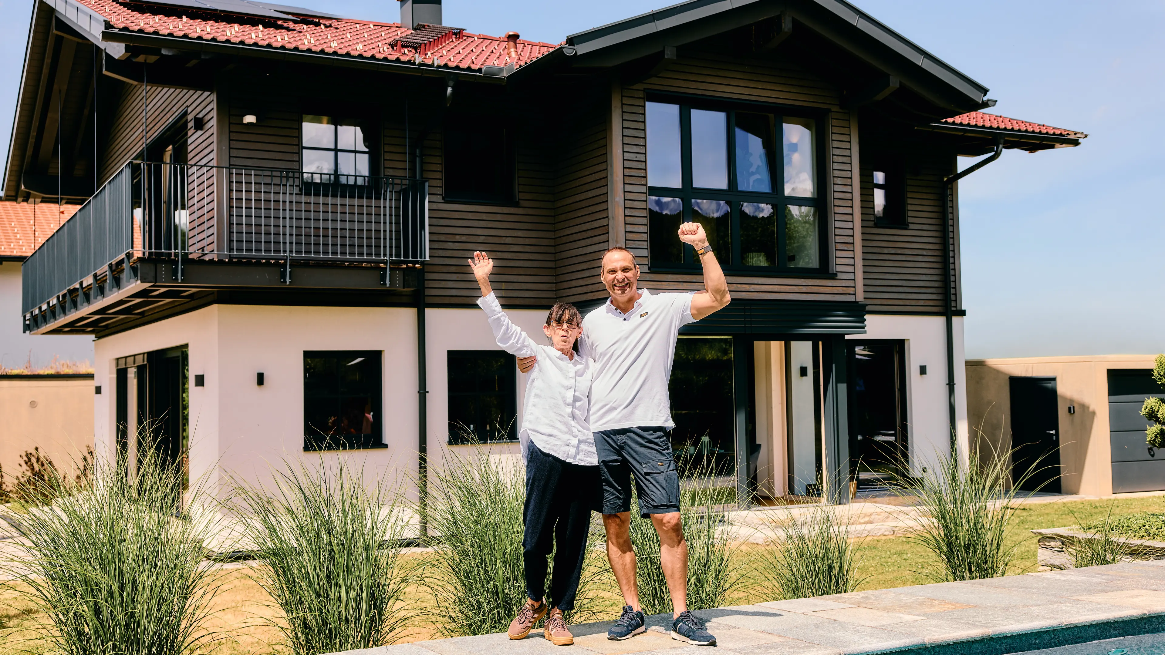 Michael, der Gewinner vom Traumhaus am Chiemsee mit seiner Frau vor dem Traumhaus am Chiemsee